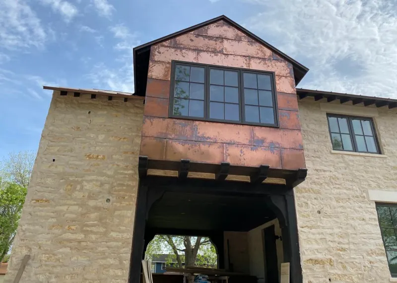 Copper metal panel facade on a stone building for Roof Repair in Winslow