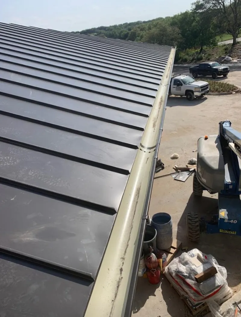 Standing seam panel and gutter detail on a metal roofing jobsite in Winslow